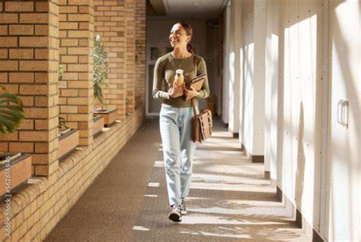 A stylish student walking through a school hallway with a retro inspired outfit
