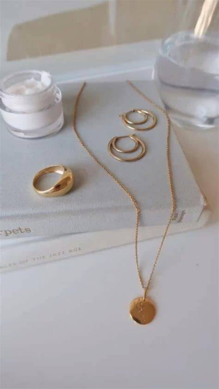 Minimalist gold jewelry and straw hat accessory for beach ceremony