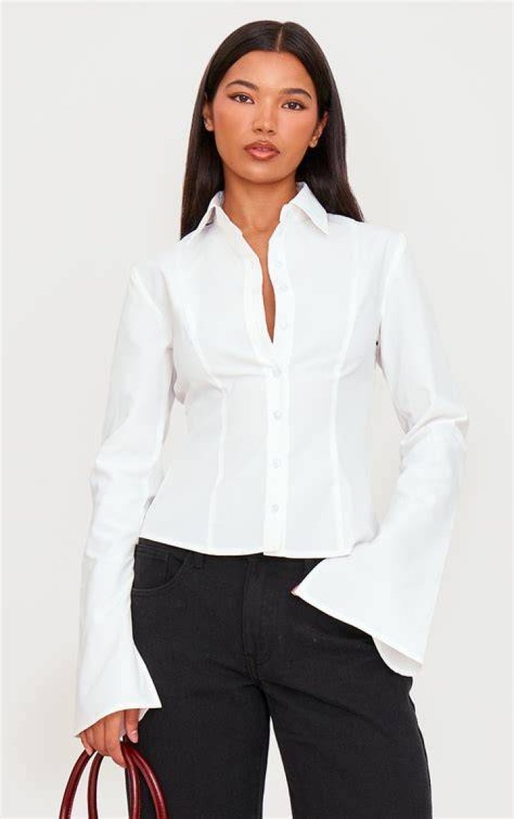 Petite woman wearing fitted white linen shirt and high waisted black trousers