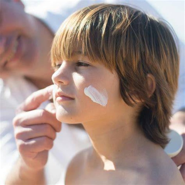 sunscreen spray being applied to men's scalp during hair styling
