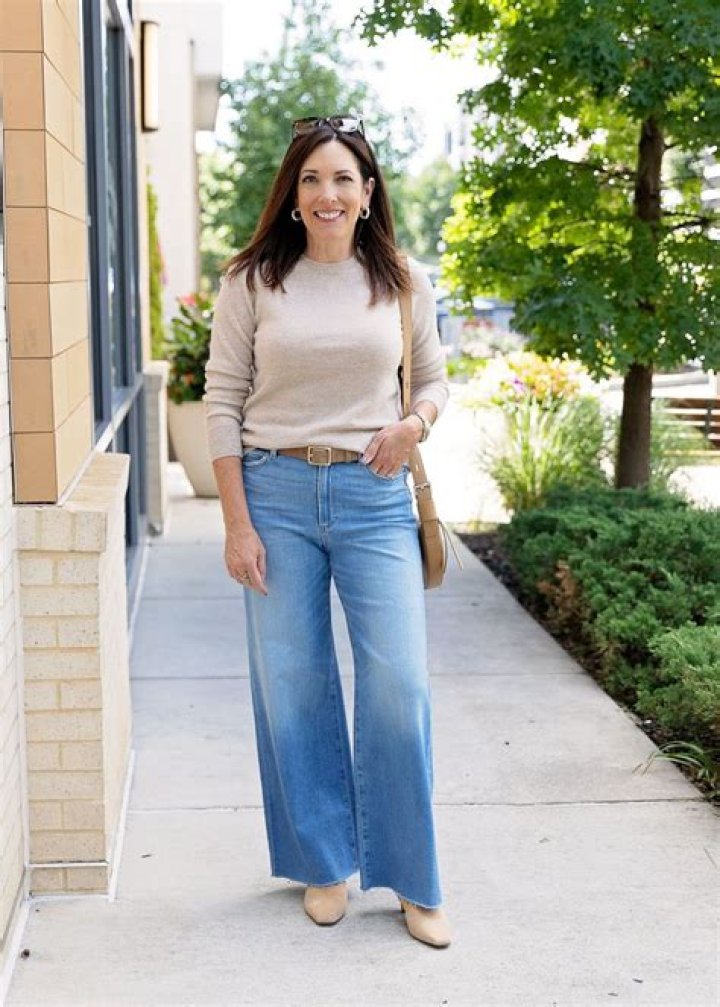 Woman in wide leg pants bending over plants