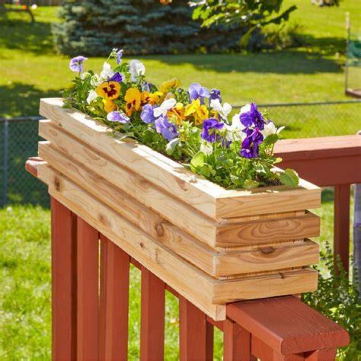 Woman painting wooden planter box