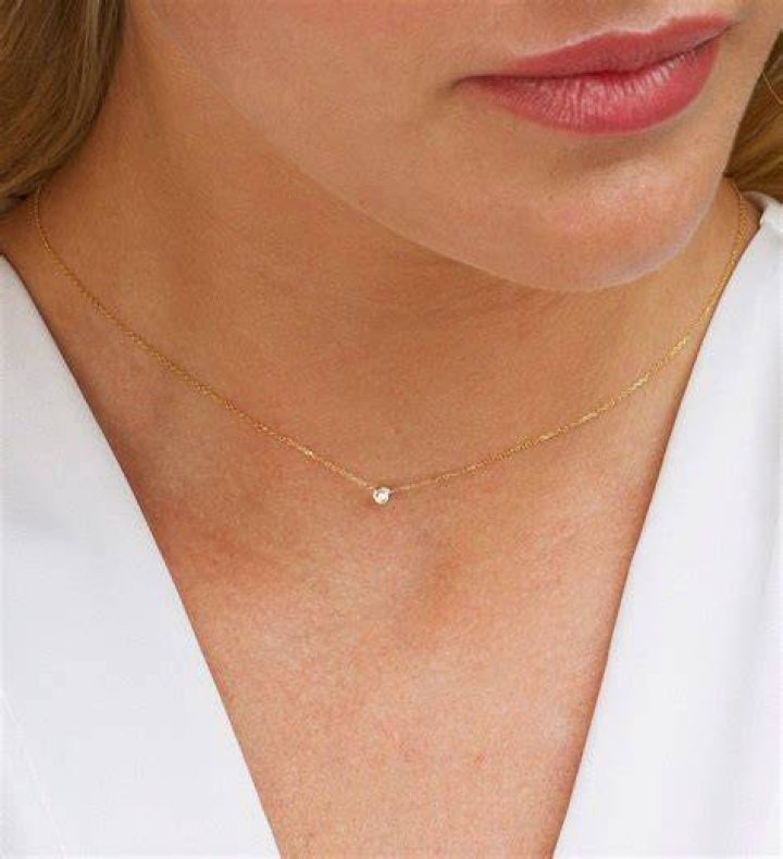 Woman wearing dainty gold jewelry and a summer blazer