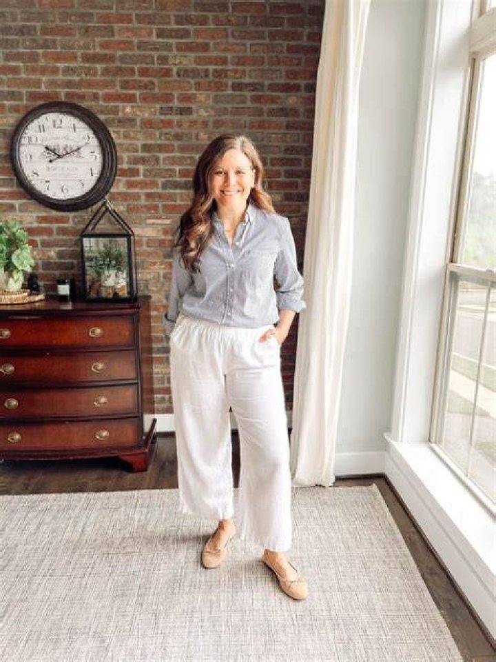 Woman wearing white linen pants and a fitted striped top