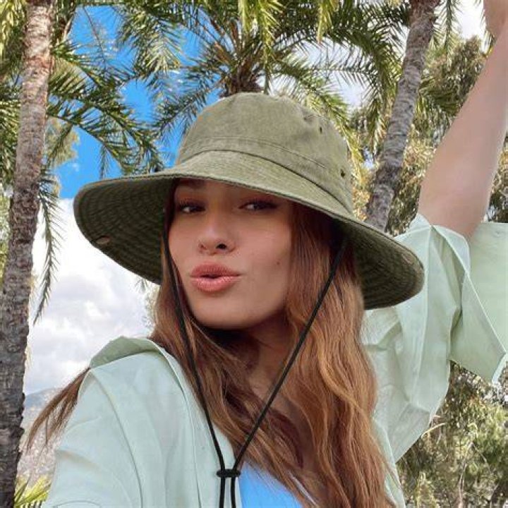 Women wearing bucket hat and sundress at baseball game summer fashion